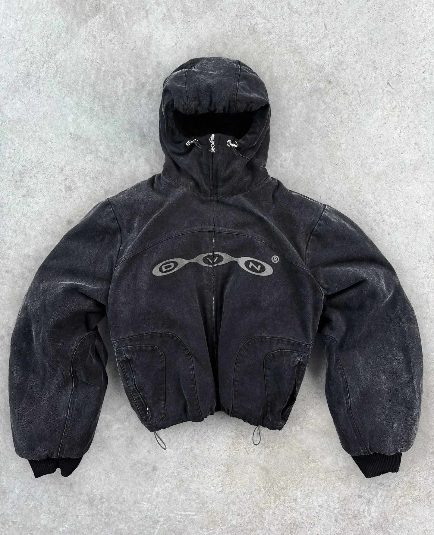 Black distressed denim hooded jacket with silver dvn logo across the chest in harajuku hip hop style