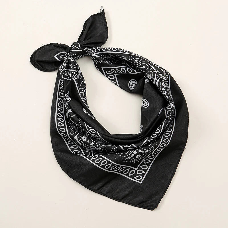 Black bohemian print bandana with white paisley and skull patterns tied in a knot for printed headbands hiphop wrist wraps face use
