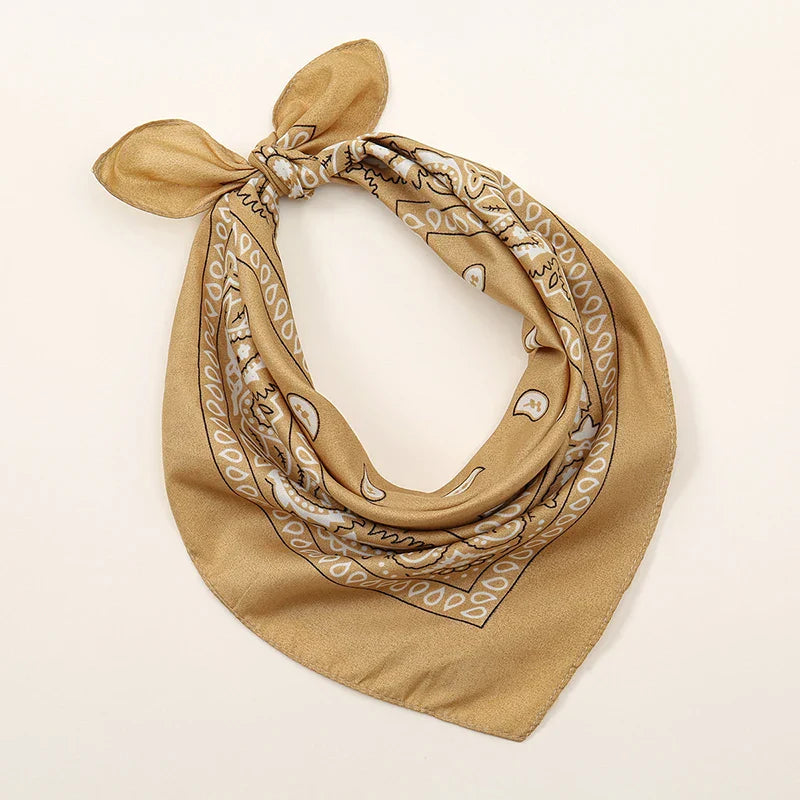 A tan bohemian print bandana with white and black paisley pattern tied in a neat knot, ideal for printed headbands hiphop and wrist wraps face use