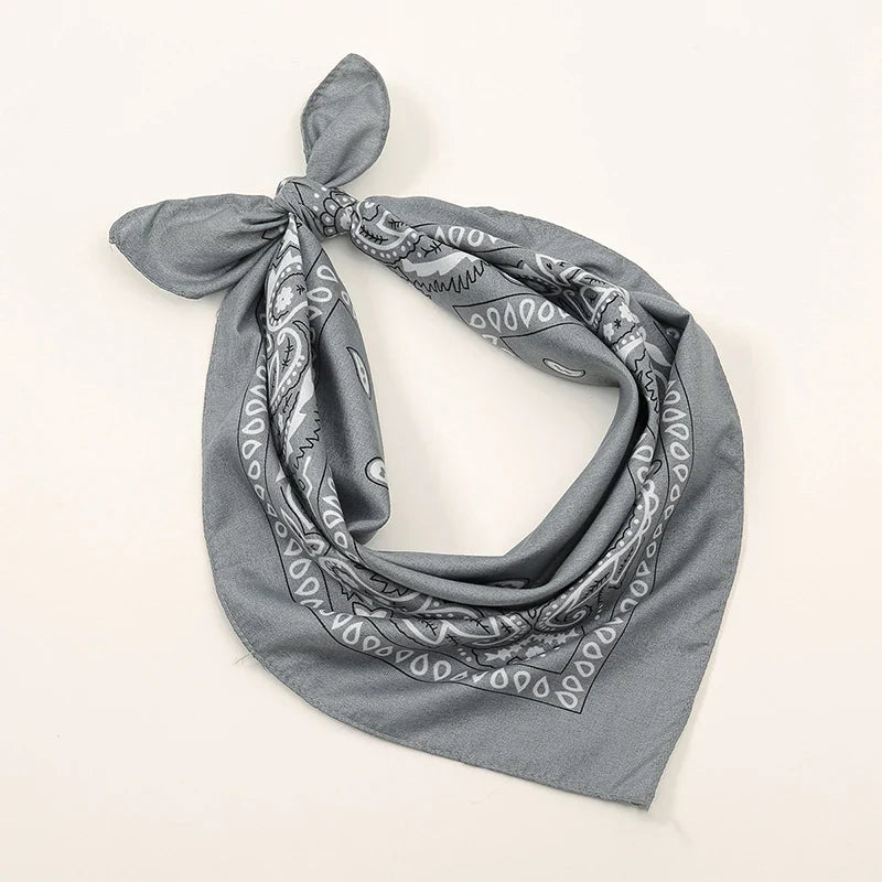 Gray bohemian print bandana with white paisley geometric patterns tied in a knot for printed headbands hiphop wrist wraps face use