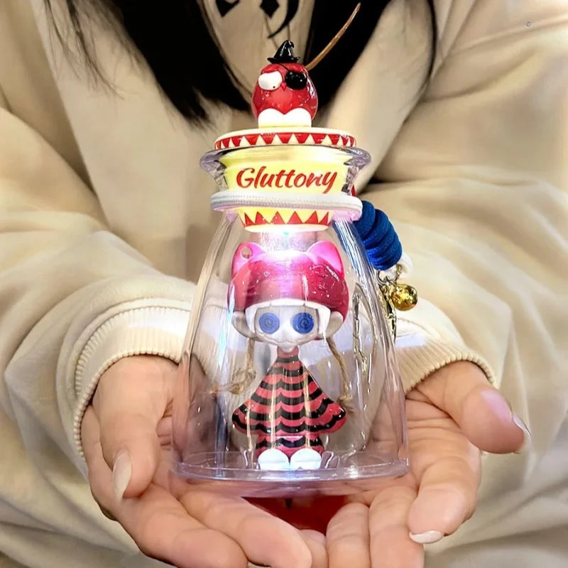 A pink and black striped bottle music blind cute horror figure model gift with blue eyes and yellow gluttony label inside glass