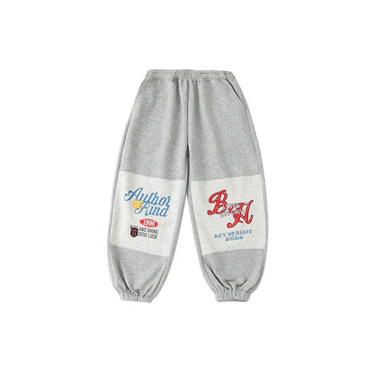 Gray sweatpants with white patch panels featuring colorful graphic prints and text in kids streetwear jazz clothes set
