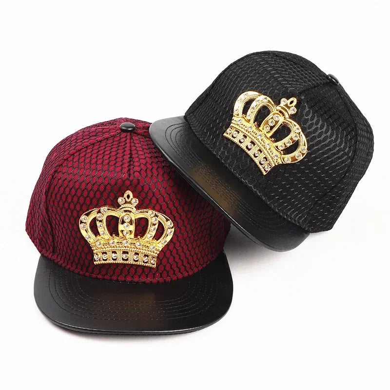 Two snapback hats in deep red and black featuring a gold royal king crown emblem with rhinestones on front panels