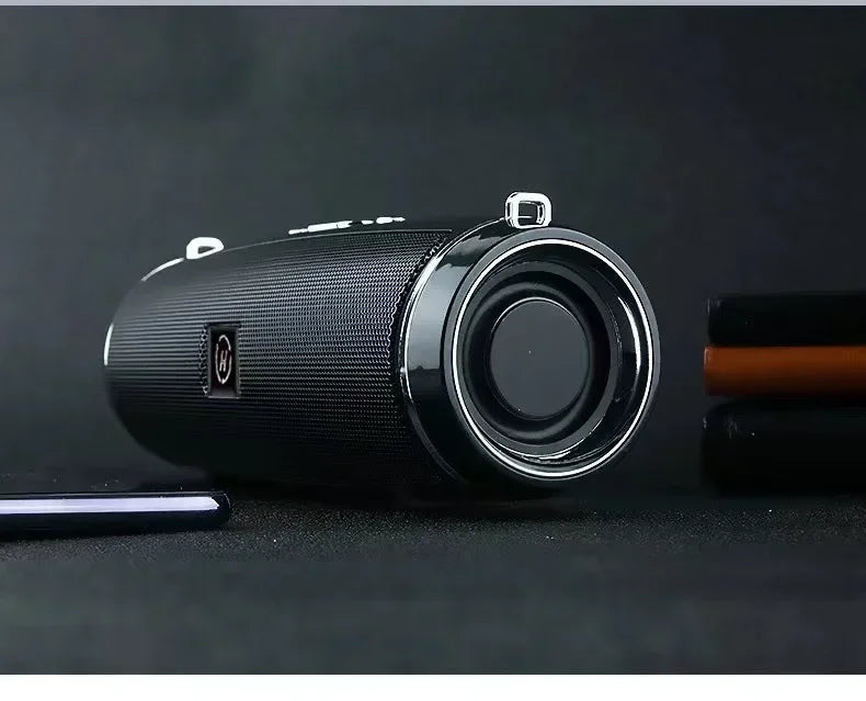 Black cylindrical portable wireless speaker with textured mesh grille and chrome driver for high power outdoor stereo surround tws use