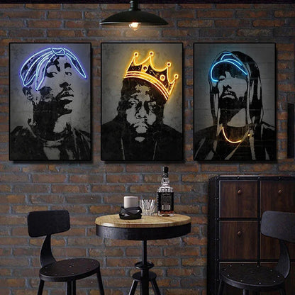 Three framed neon canvas print art posters featuring 2pac and hip hop icons with blue and gold outlines on brick wall