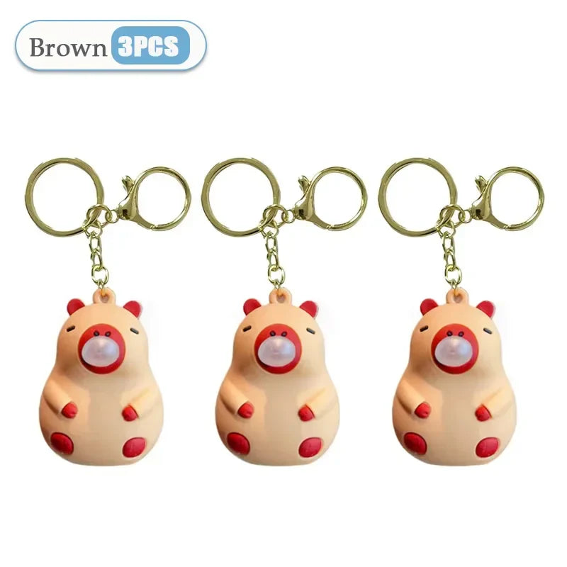 Set of three brown plush capybara doll pinch keychains with red accents and gold rings for spit bubble decompression and schoolbag doll pendant decoration