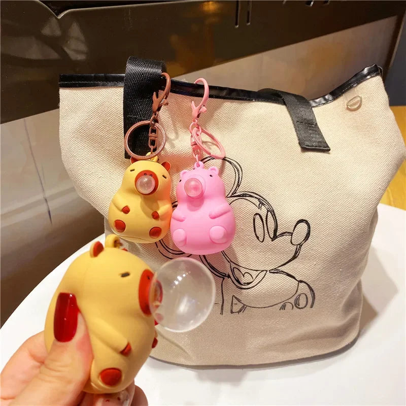 Yellow and pink capybara doll pinch music keychain toys with red accents and spit bubble decompression features for schoolbag doll pendant decoration