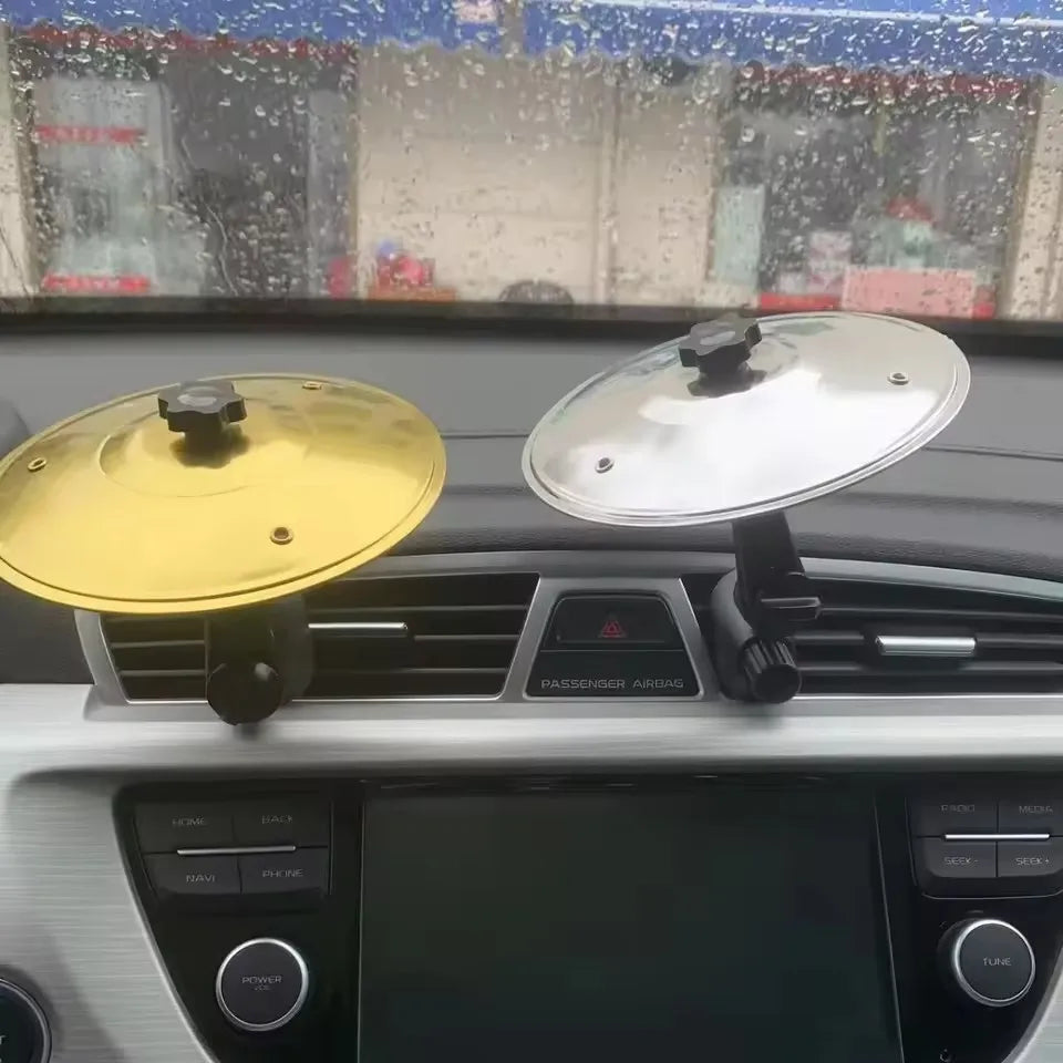 Two circular gold and silver car crash cymbals with black adjustable sticks air vent clamps as mini drum car holders