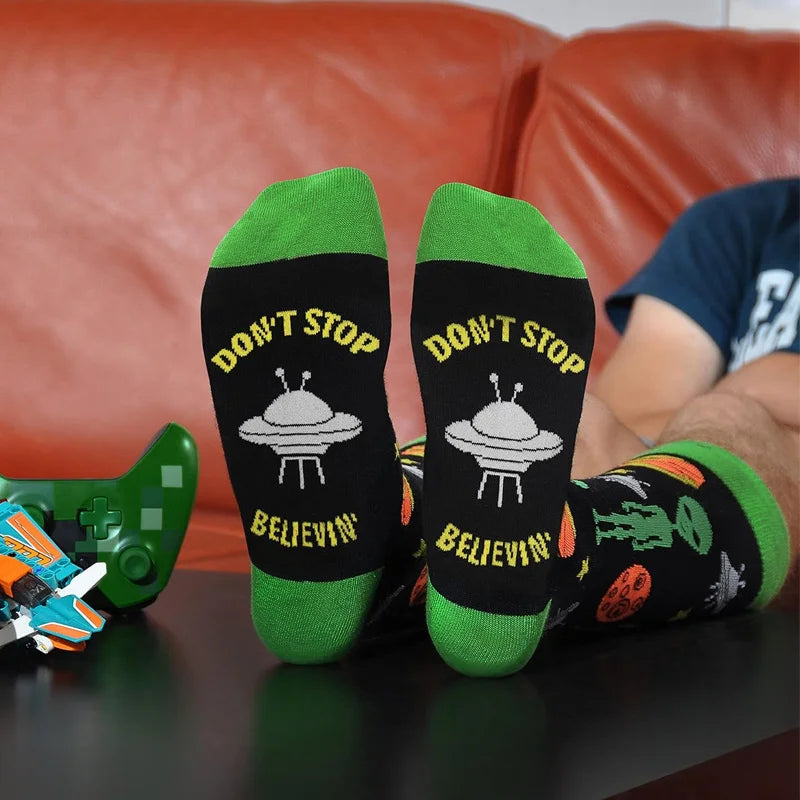 Black cavertin men’s programming alien sasquatch socks with green cuffs, white ufo graphic, and yellow don’t stop believin text