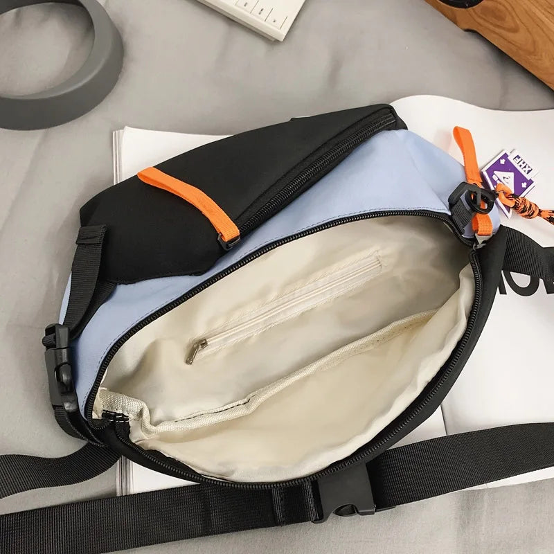 A sleek two-tone chest rig bag women nylon fanny pack streetwear with black light blue fabric and orange zipper pulls