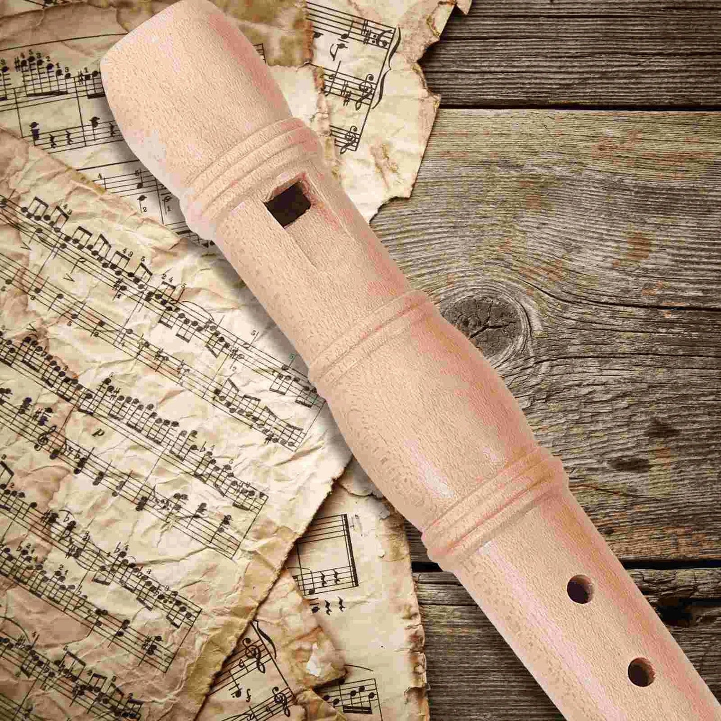 A light pink wooden children flute recorder with smooth polished finish and evenly spaced finger holes educational toy