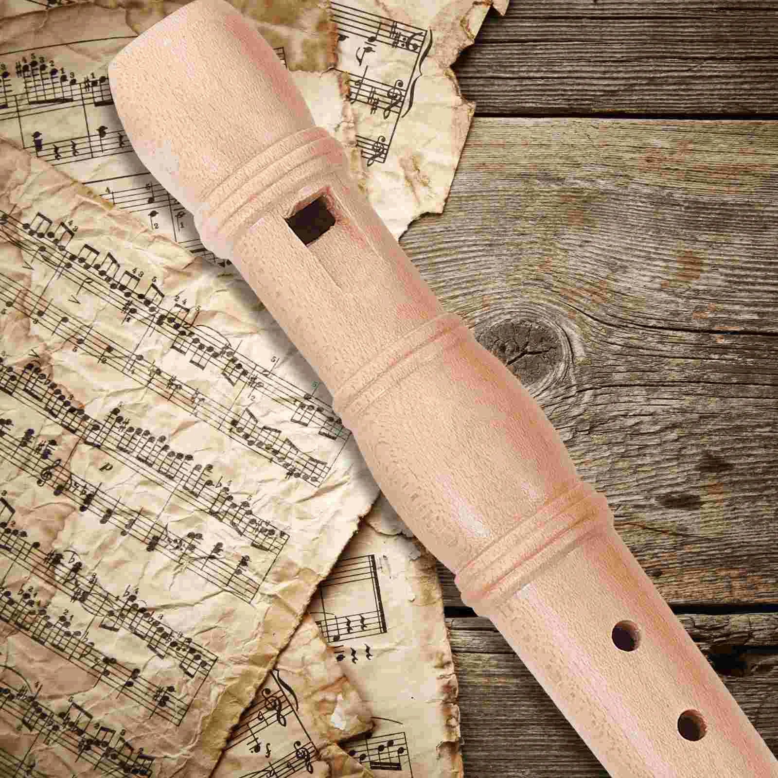 A light pink wooden children flute recorder with smooth polished finish and evenly spaced finger holes educational toy
