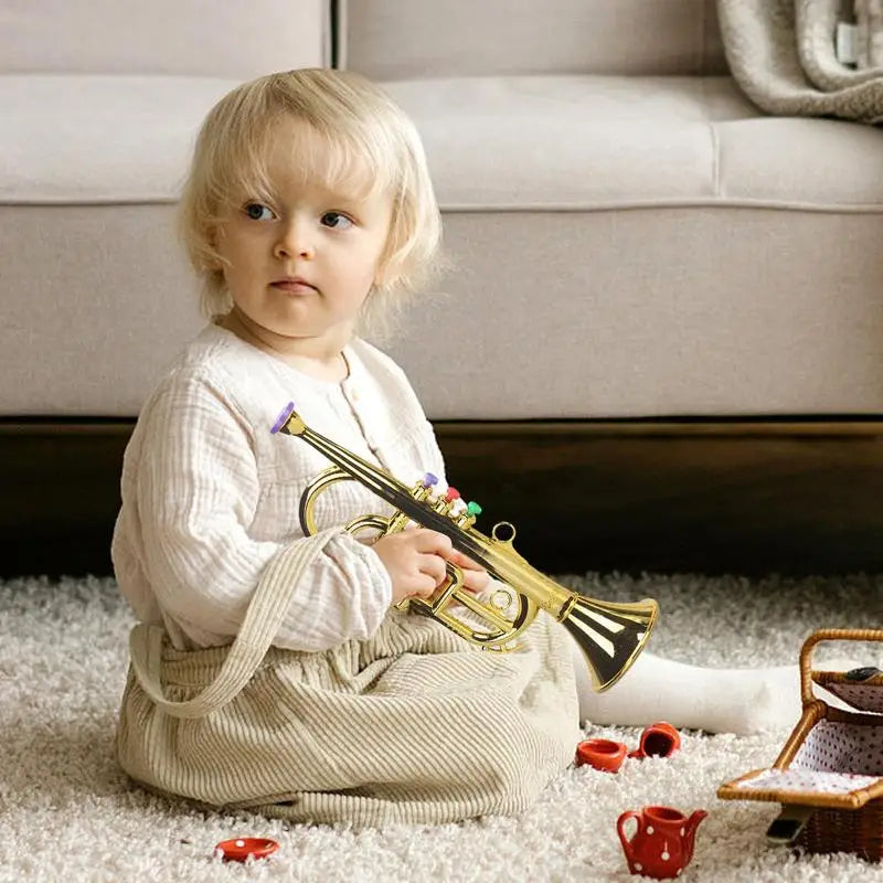 Gold-colored plastic toy trumpet with colorful buttons and purple mouthpiece simulated musical brass instrument for house music equipment