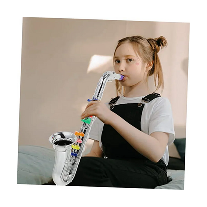 A child holds a shiny silver brass toy saxophone with colorful plastic keys from children’s saxophone music toys