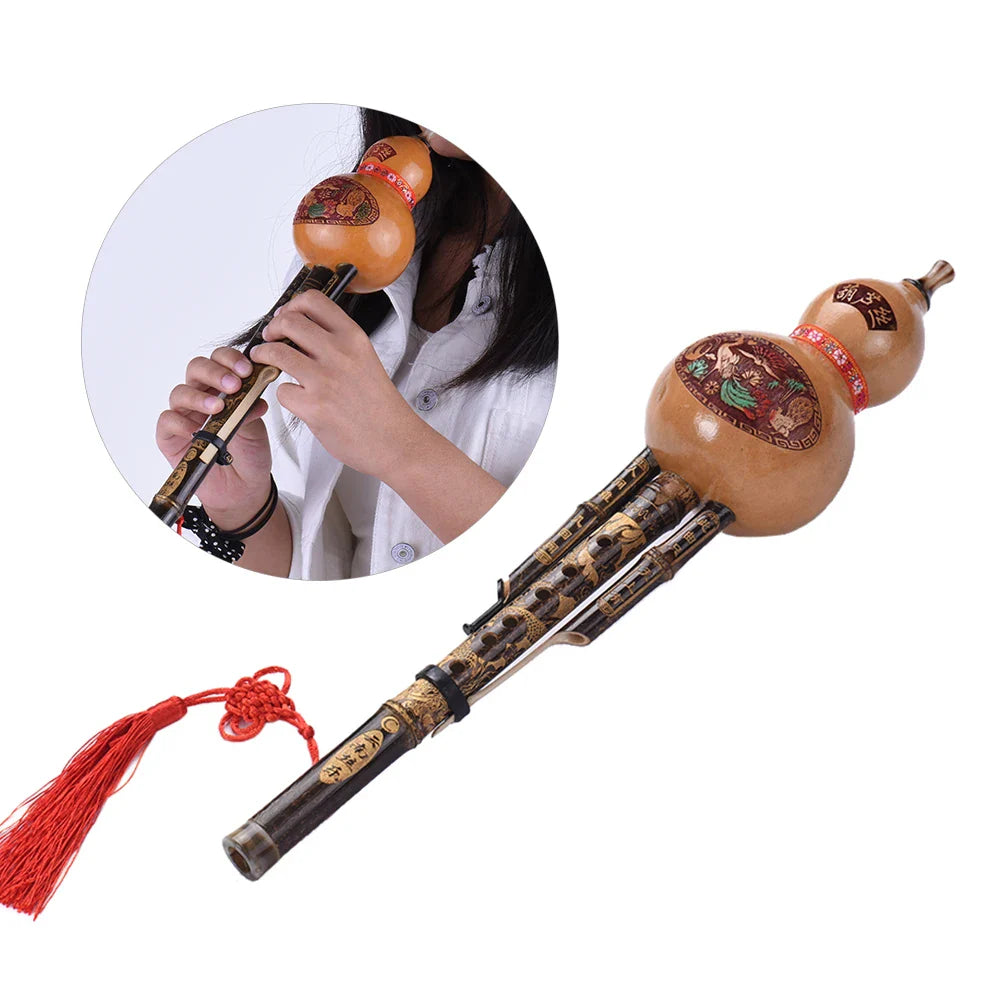 Traditional Chinese black bamboo hulusi with light brown polished wood, gold engravings, red tassels, ethnic musical instrument