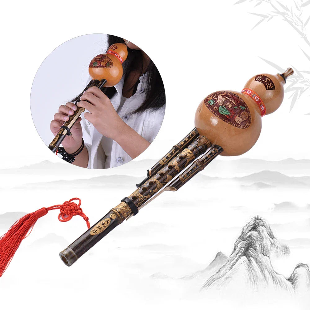 Hand-carved black bamboo hulusi flute with intricate gold and red designs and red tassel ethnic musical instrument