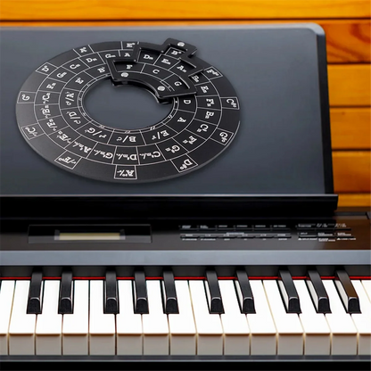 Black circular wooden chord wheel with white lettering and central cutout on electronic keyboard for music theory