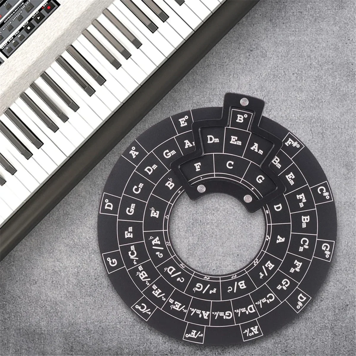 Black wooden circle of fifths guitar chord wheel with white lettering and raised tabs for music theory reference