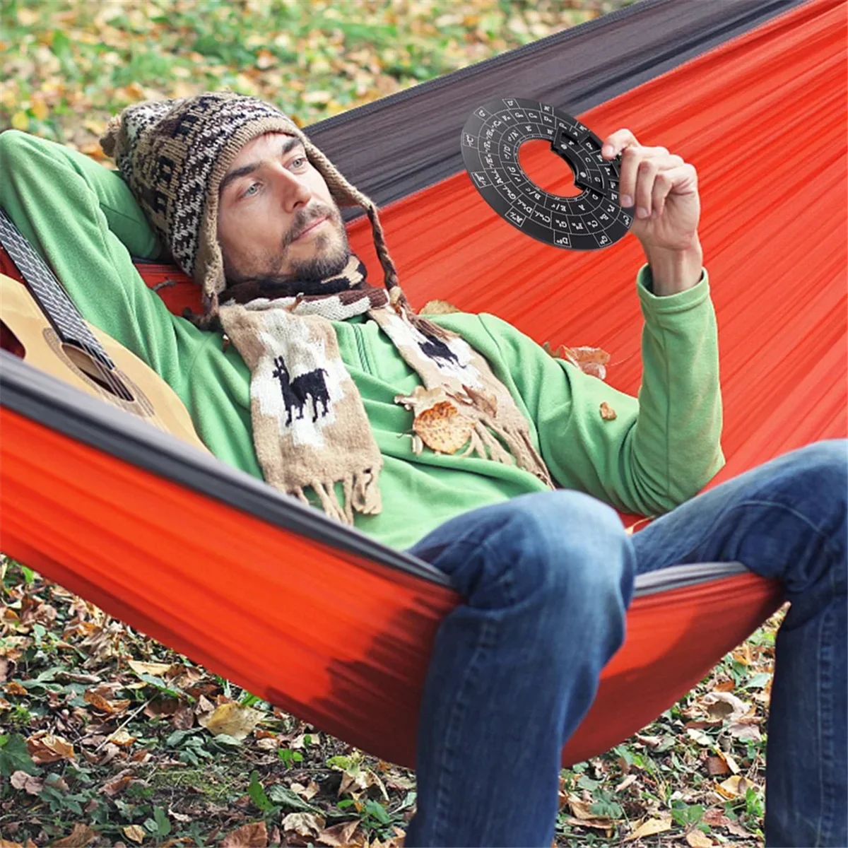 Orange hammock with black trim displayed with wooden circle of fifths guitar chord wheel for music theory and guitar accessories
