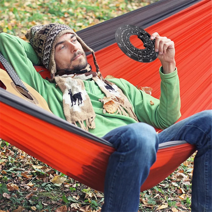 Orange hammock with black trim displayed with wooden circle of fifths guitar chord wheel for music theory and guitar accessories