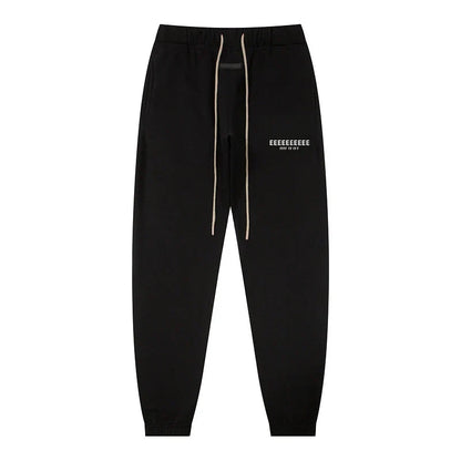 Black jogger pants with beige drawstrings and white text logo on left thigh made of quality fleece sweatshirts for classic brand hoodies hiphop streetwear oversize sets