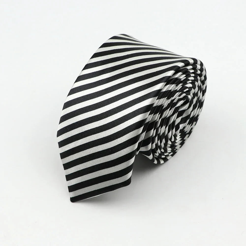 A sleek black and white silk skinny tie with diagonal stripes showcasing an elegant width necktie party accessory