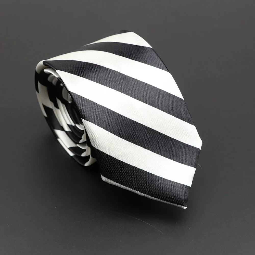 A sleek black and white silky narrow necktie neatly rolled featuring classic musical notes printed design