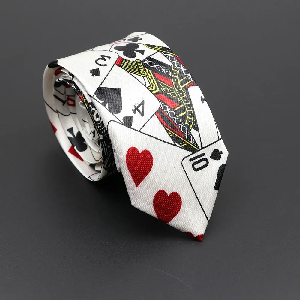 A white silk tie with bold playing card design featuring red hearts black spades clubs and gold-trimmed royal cards