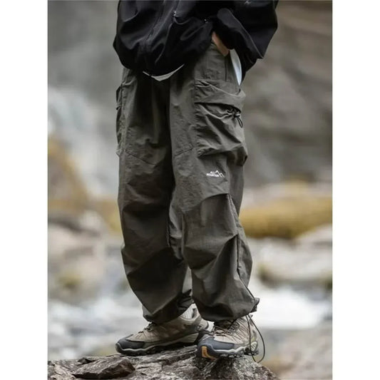 Dark olive green waterproof hip hop cargo pants with multiple pockets and subtle brand logo for outdoor sports use