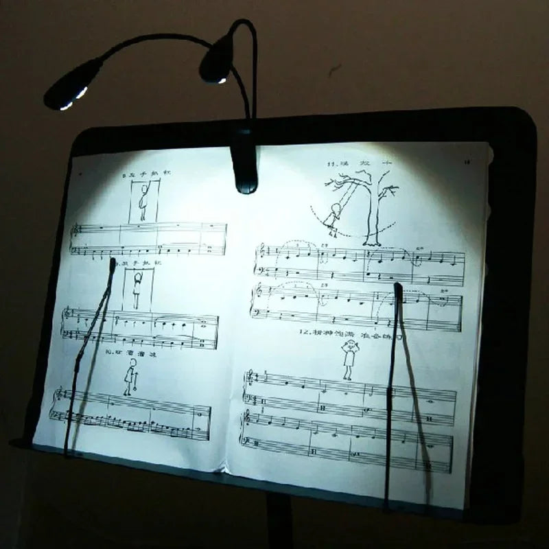 Black clip-on music stand light with dual arms and 4 leds illuminating sheet music for piano violin musical use