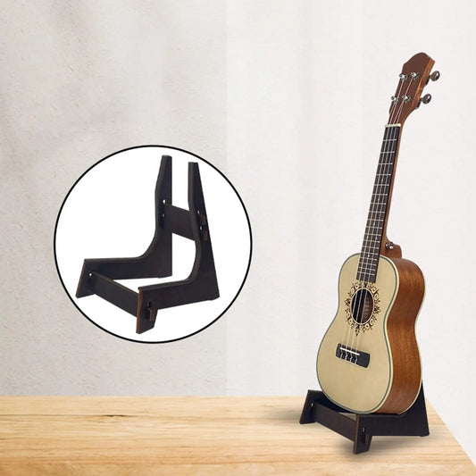 Black wooden collapsible ukulele storage rack holding a light brown acoustic ukulele with gold detailing stand floor holder