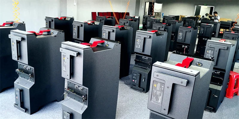 Black industrial-grade electrical switchgear units with red safety handles and metallic panels for professional sound equipment