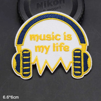 White embroidered clothes patch with blue and yellow headphones and music is my life text for boy clothing type beat music