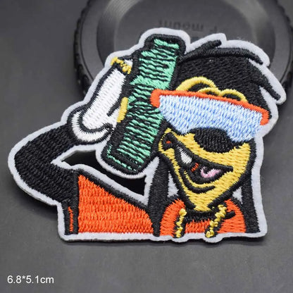 Colorful embroidered clothes patch of cartoon boy with black hair blue orange goggles holding green comb for boy clothing type beat music