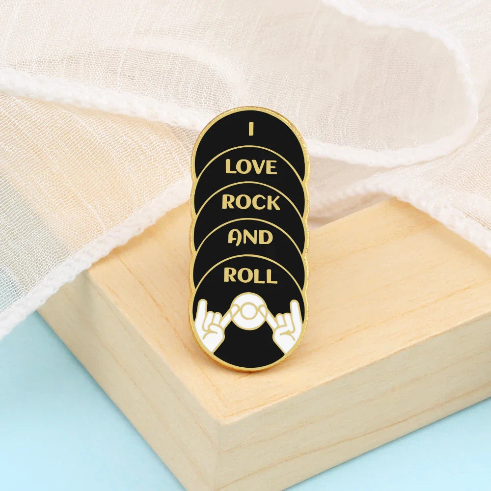 Black and gold music note enamel pin with stacked circular design featuring hand gesture and vinyl for musician gifts
