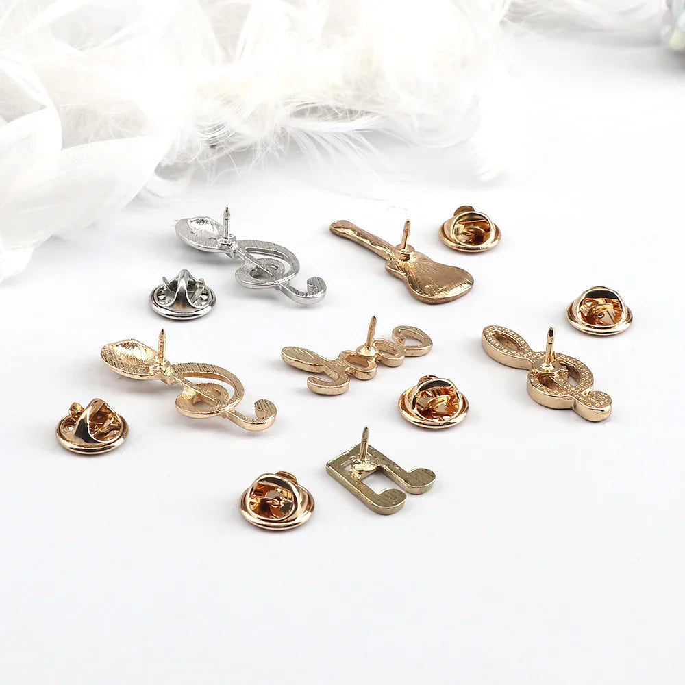 A collection of gold and silver music note enamel brooches featuring fashion guitar microphone and piano notes lapel designs