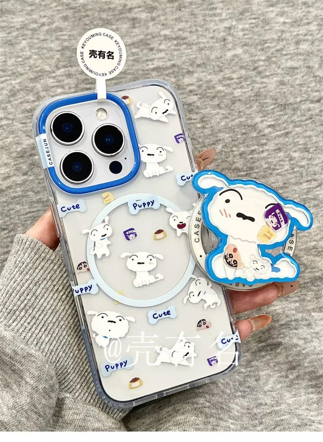 Transparent magnetic phone case with white cartoon dog stickers and a blue pop-up stand for crayon shin chan models