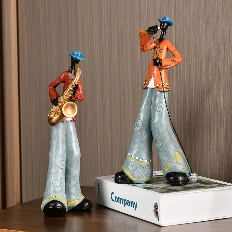 Two stylized musician figurines in red and orange jackets with instruments creative american band crafts statue sculpture
