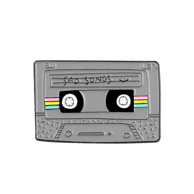 Gray enamel pin shaped like a cassette tape with sad songs label and rainbow stripes creative music symbol alloy brooch