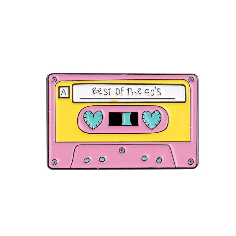 Pink and yellow enamel pin shaped like a cassette tape with heart cutouts featuring creative music symbol design