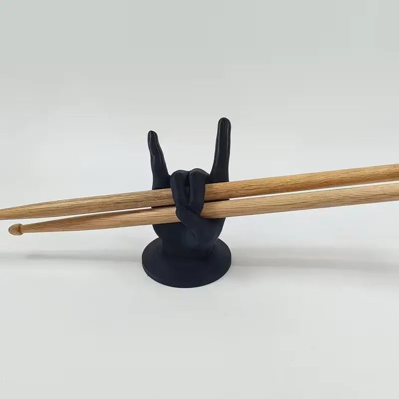 Black plastic creative rock hand drumstick display stand shaped like a hand making the rock on sign for drummers