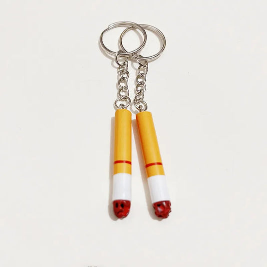 A pair of yellow and white creative simulation pvc cigarette key chains with red tips as bag pendant accessories