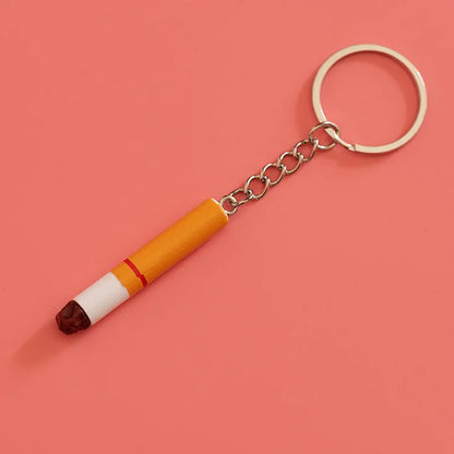 A creative simulation pvc cigarette key chain in yellow and white with a red stripe and brown ash tip as bag pendant accessories