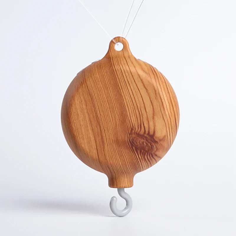 A smooth light brown wooden crib bell rotary with natural wood grain and gray metal hook for baby hand-eye coordination