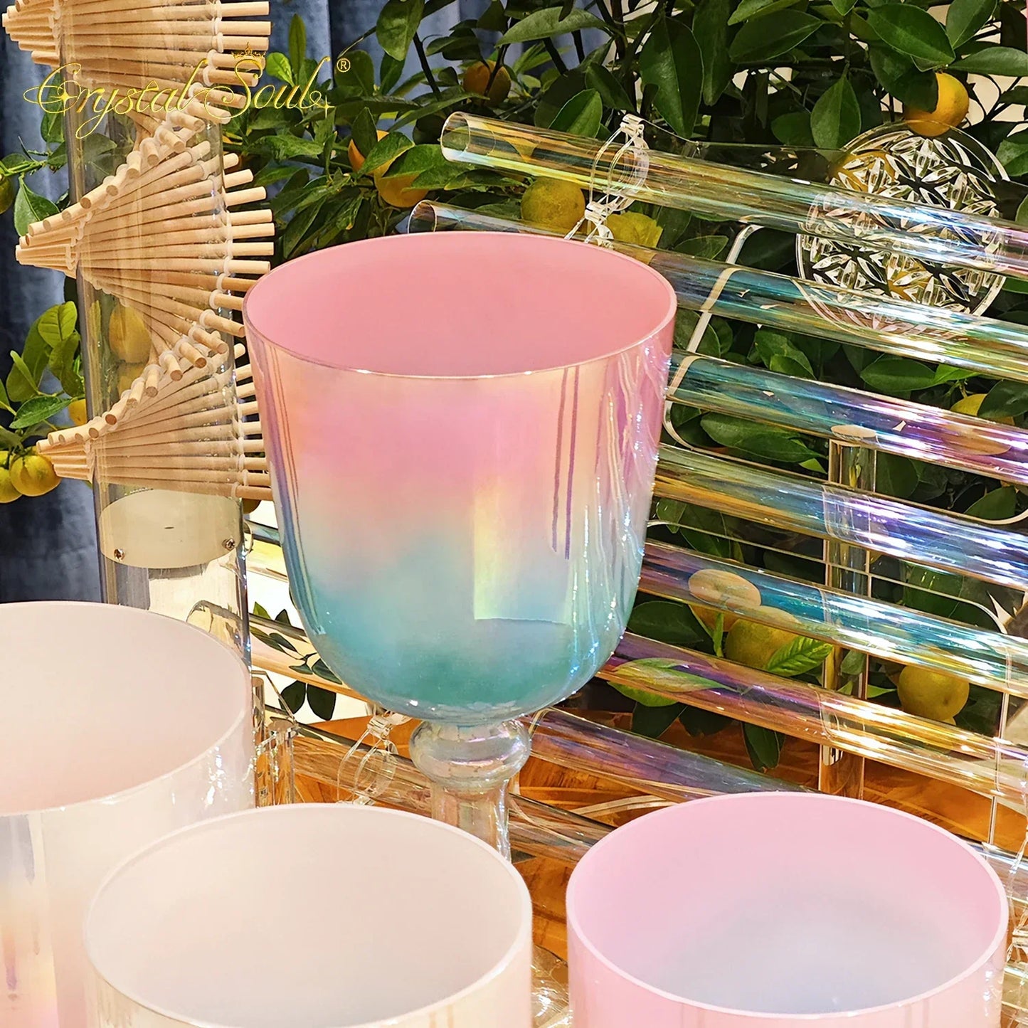 A crystal soul essential glass singing bowl with pink to blue iridescent finish and clear stem for sound therapists essential use