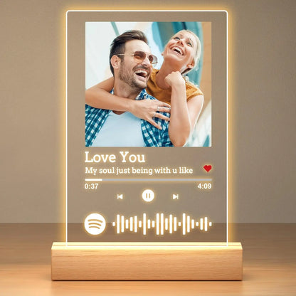 A glowing personalized music plaque with customized spotify music interface on acrylic glass and wooden base