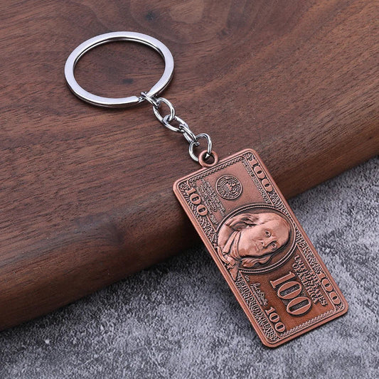 Copper-colored cute vintage dollar model keychain with embossed details and silver metal ring matching airpods keyrings