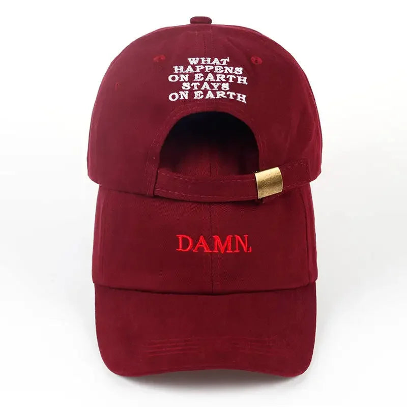 Back view of a maroon embroidered dad hat with what happens on earth stays on earth text and gold-tone strap adjustment