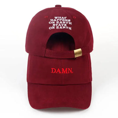 Back view of a maroon embroidered dad hat with what happens on earth stays on earth text and gold-tone strap adjustment