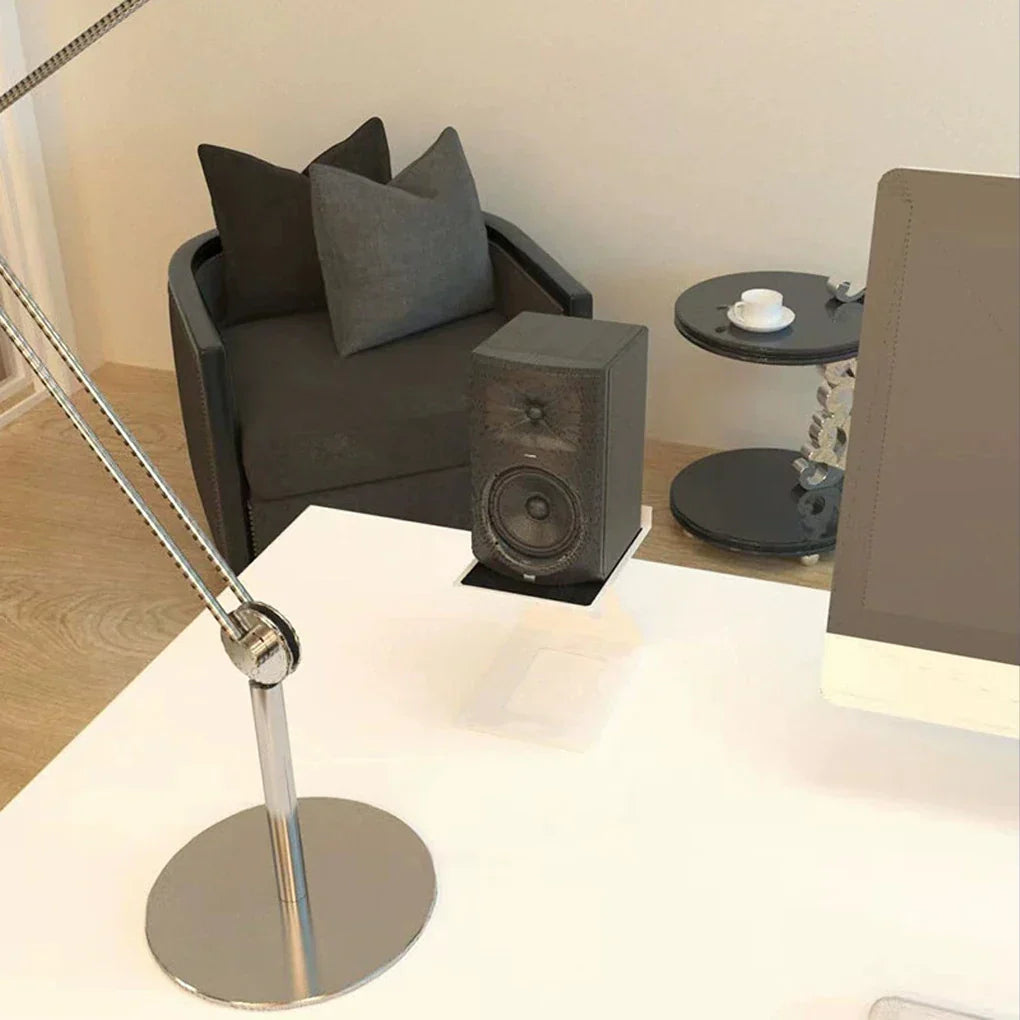Black rectangular studio monitor speaker with woofer and tweeter grille on a speaker stand professional for bookshelf speakers